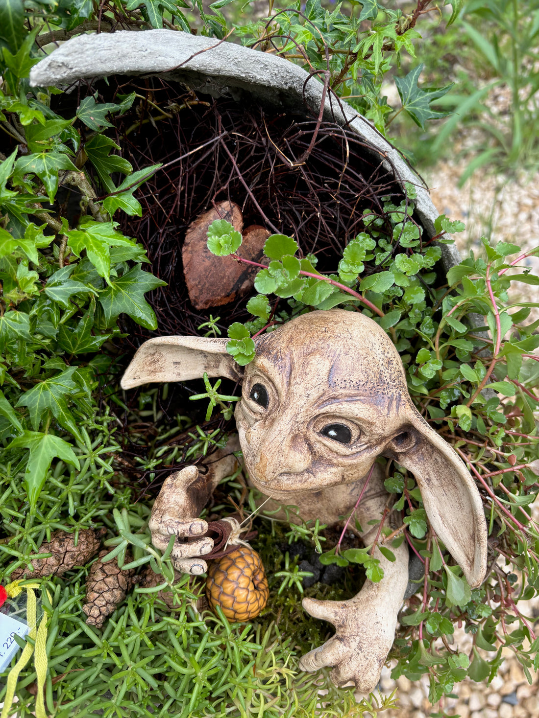 Verspielte Gartenfigur zwischen Pflanzen im Haselhof