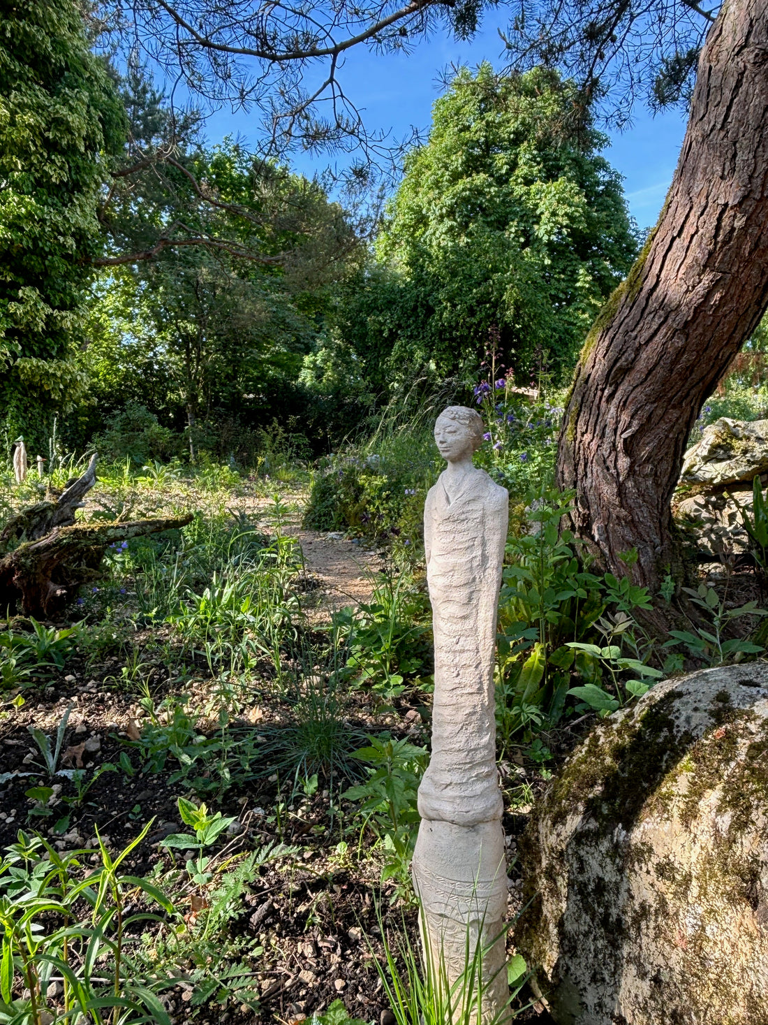 Steinskulptur neben Baum im Garten des Haselhofs
